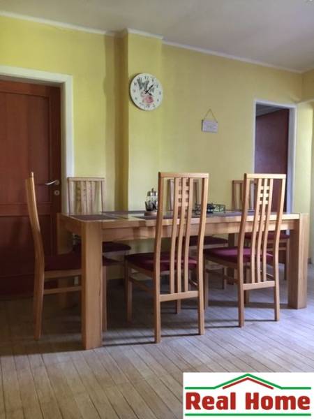 Ebédlő egy családi házban, székekkel és asztallal, fa dekorációjú padlón.