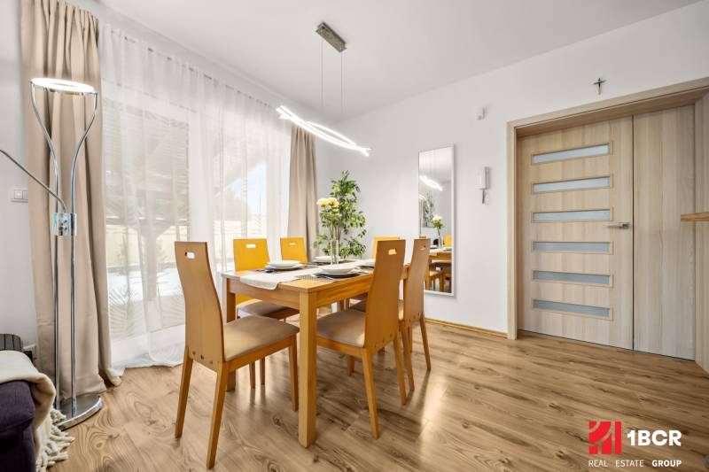 Ebédlő faasztallal és fa dekorációjú padlóval egy családi házban.