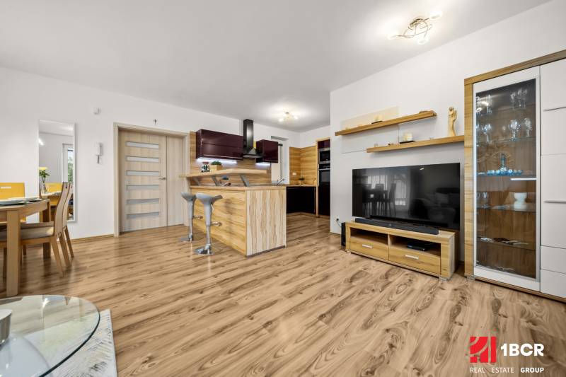 Nappali családi házban konyhával és fa dekoros padlóval.