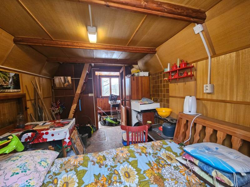 A faház belső tere fa dekorációval, bútorokkal és konyhai eszközökkel.