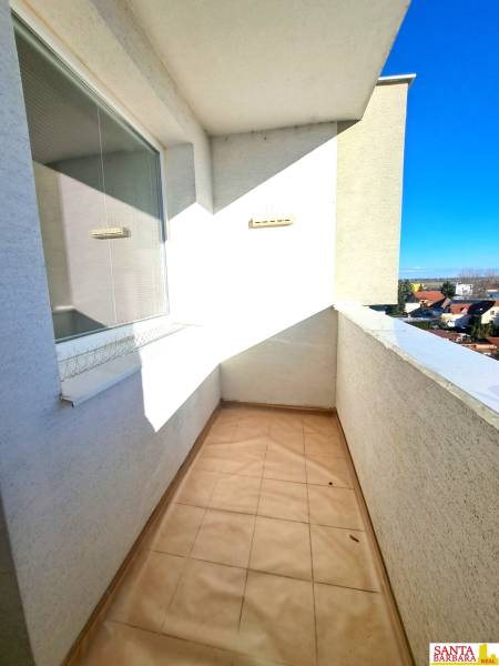 A négy szobás lakás erkélye, kilátással a háztetőkre és a tiszta égboltra.