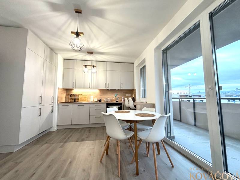 Konyha egy háromszobás lakásban fa dekor padlóval és erkéllyel.