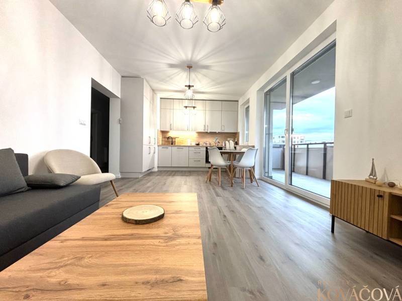 Nappali fa mintás padlóval és étkezőasztallal egy háromszobás lakásban.