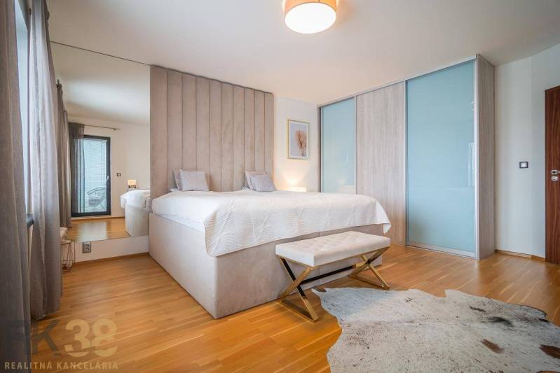 Hálószoba családi házban, ággyal, fa dekorációjú padlóval és szőrmés szőnyeggel.