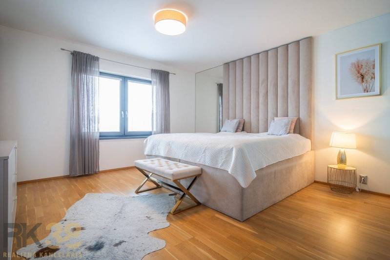 Hálószoba családi házban ággyal, fa dekoros padlóval és szőrmeszőnyeggel.