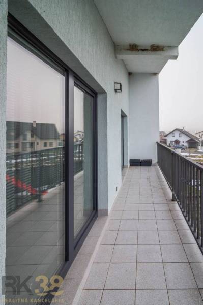 A Krátka utcai családi ház erkélye Spišské Bystréban csempével és üvegkorláttal.