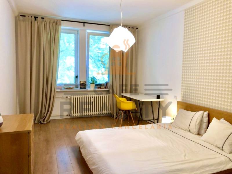 Hálószoba egy kétszobás lakásban fa dekorációs padlóval és íróasztallal.