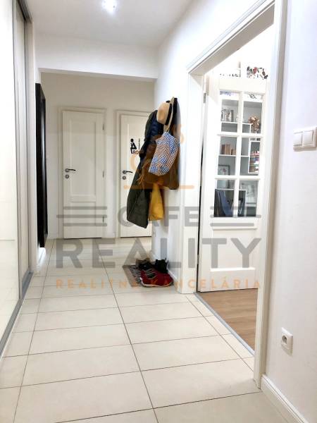 Folyosó egy kétszobás lakásban beépített szekrénnyel és csempével.