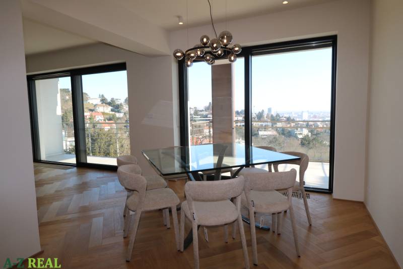 Ebédlő egy 4 szobás lakásban üvegfallal és fa dekoros padlóval.