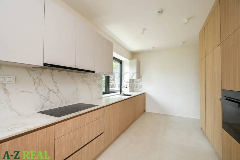 Konyha egy 4 szobás lakásban fehér szekrényekkel, márvány felülettel és fa dekorációval.