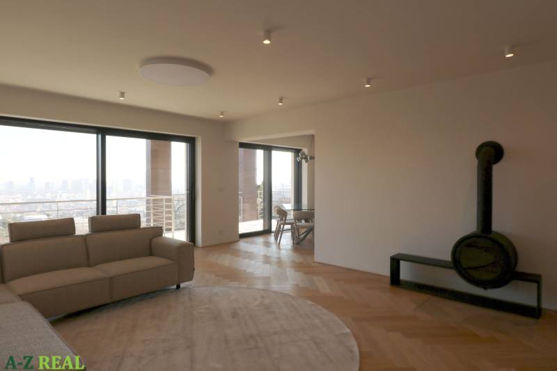 Nappali kanapéval, kandallóval és fa dekorációjú padlóval egy 4 szobás lakásban.