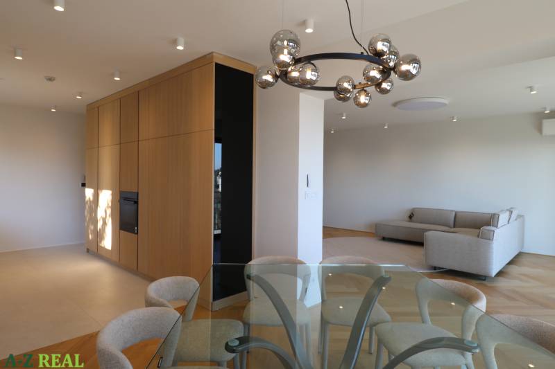 Nappali étkezőasztallal, kanapéval és lámpával egy 4 szobás lakásban, fa dekorációjú padlóval.