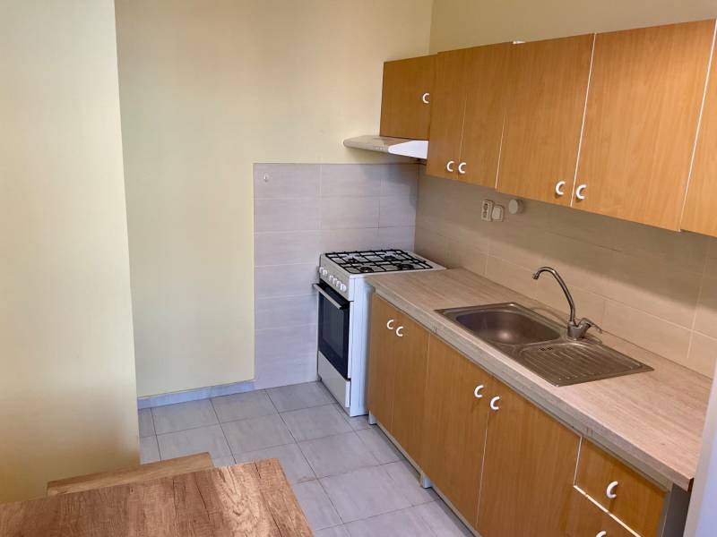 Konyha egy háromszobás lakásban gáz tűzhellyel és fa szekrényekkel.