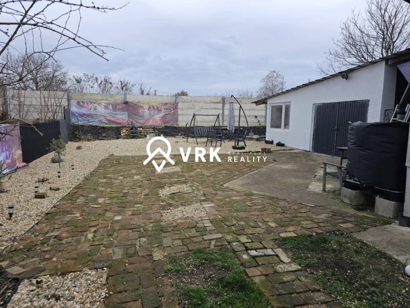 Családi ház udvara Hernádkakon térkővel és kerti ülőgarnitúrával a telken.