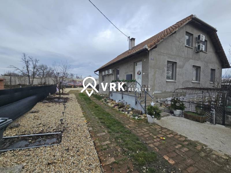 Családi ház Hernádkakon kerttel, kavicsos felhajtóval és fa elemekkel.