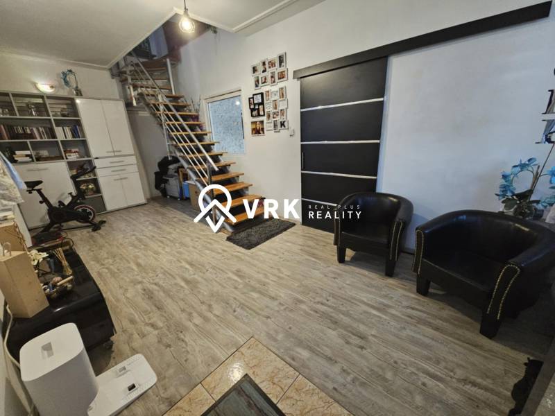 Családi ház belső tere modern lépcsőkkel és fa dekorációjú padlóval.