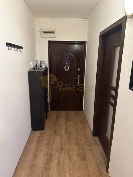 Előszoba fa mintázatú padlóval egy kétszobás lakásban.