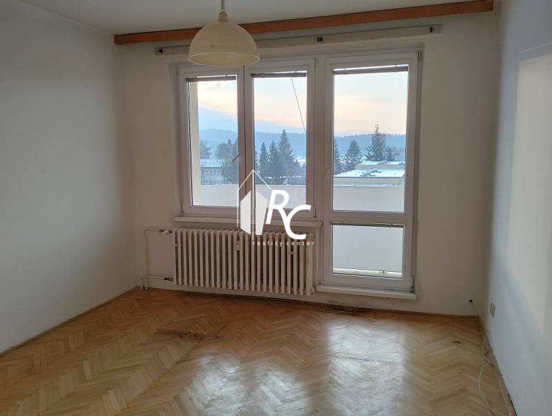 Szoba világos belső térrel és fa dekorációjú padlóval egy kétszobás lakásban.