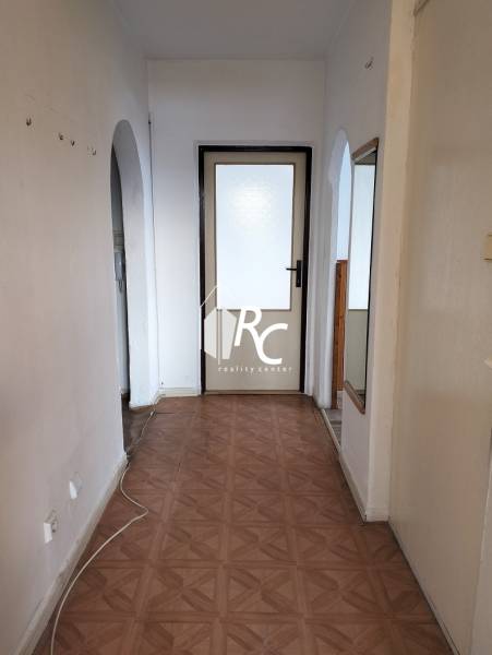 Boltíves folyosó és fa dekorációjú padló a kétszobás lakásban.