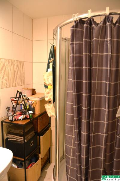 Fürdőszoba áthidalással és tárolóhelyekkel egy háromszobás lakásban.