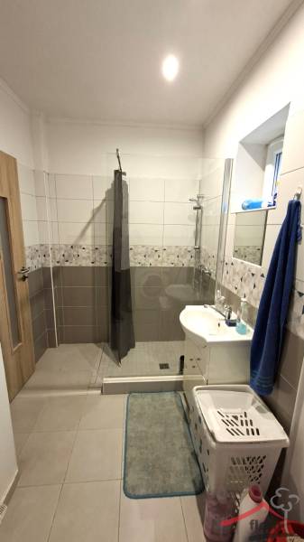 Fürdőszoba családi házban nyitott zuhanyzóval és kerámia burkolatokkal.