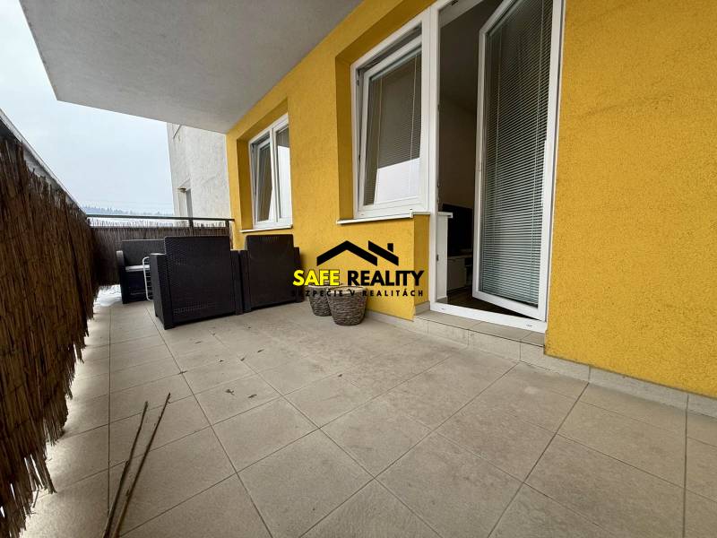 Erkély egy kétszobás lakásban Zsolnán, burkolt padlóval és kerti bútorokkal.