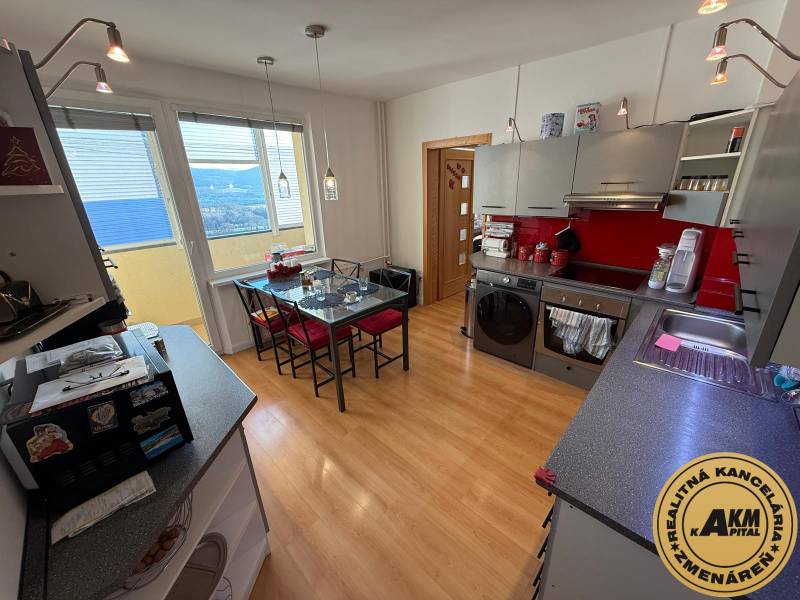 Konyha egy háromszobás lakásban, fa dekor padlóval és piros akcentusokkal.