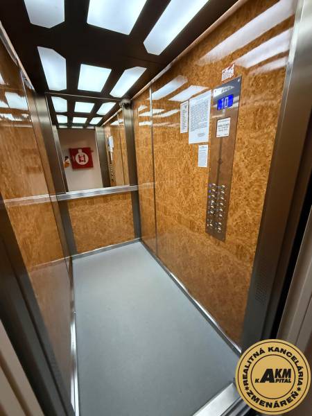 Fa dekorációval és modern világítással ellátott lift található a 3 szobás lakásban.