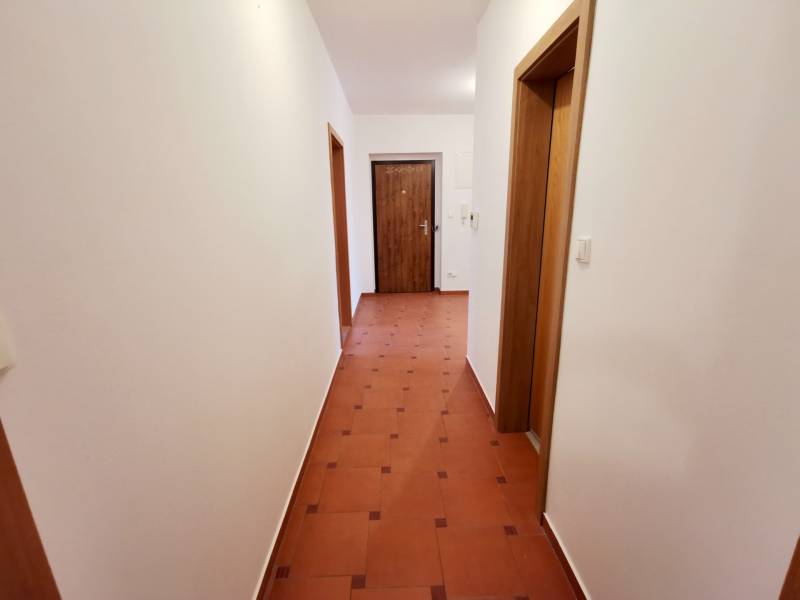 Folyosó világos falakkal és csempével egy 4 szobás lakásban.