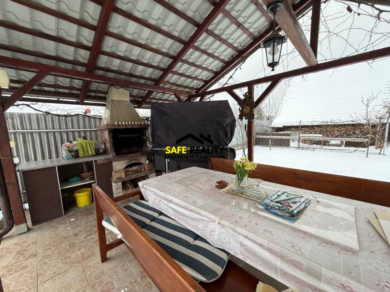 Családi ház téli terasza Rosinán kandallóval és ülőasztallal.