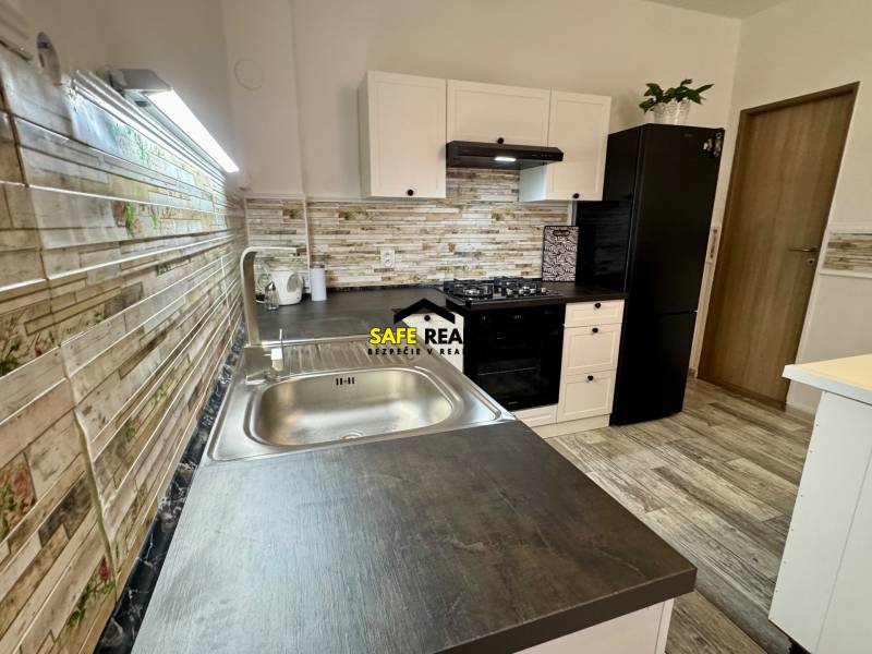 Konyha családi házban, fa dekor padlóval és modern készülékekkel.