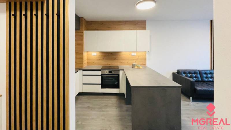 Konyha egy kétszobás lakásban fa hatású padlóval és modern konyhabútorral.