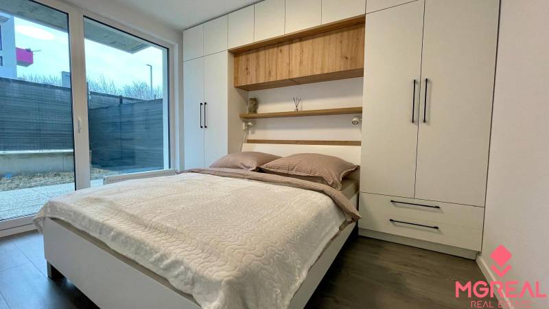 Hálószoba franciaággyal és beépített szekrénnyel egy kétszobás lakásban, fa dekorációjú padlóval.