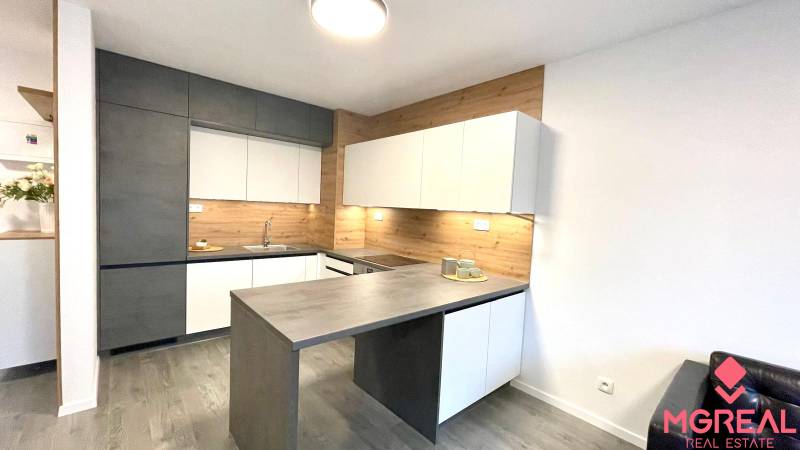 Beépített készülékekkel és fa dekorációval ellátott konyhabútor egy kétszobás lakásban.