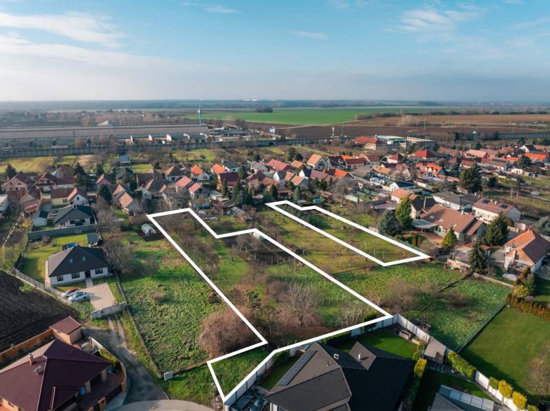 Lakóterületek Vlčkovce-ban, tágas parcellák vidéki tájra néző kilátással.