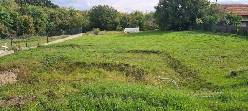 Családi ház kertje Semerovóban, zölddel és fákkal a telek szélén.