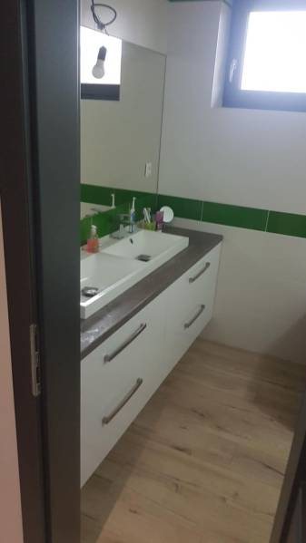 Fürdőszoba egy családi házban mosdókagylóval és fa dekorációjú padlóval.