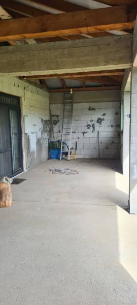 Egy családi ház belső tere ízléstelen falakkal, létrával és építőanyaggal.