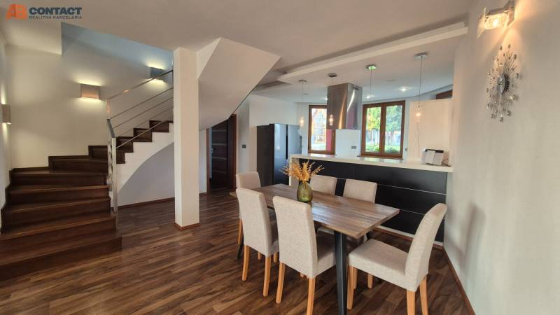 Ebédlő és lépcsőház családi házban fa dekoros padlóval, nyitott tér.