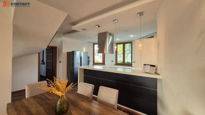 Konyha étkezőasztallal és fa dekorációjú padlóval egy családi házban.