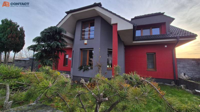 Családi ház a Krakkóvany-i Szeles utcában, fákkal és rendezett kerttel körülvéve.