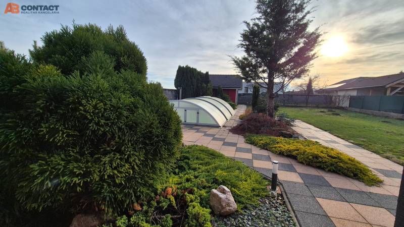 Kert a családi ház mellett a Krakovany-i Veterná utcában, medencefedéssel.