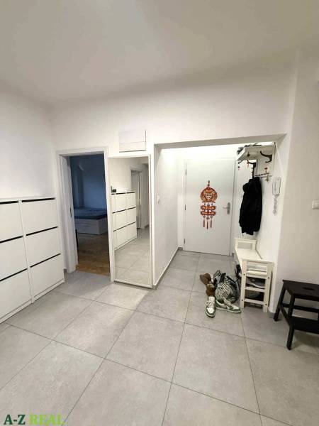 Négy szobás lakás előszobája csempével és fali tükörrel.