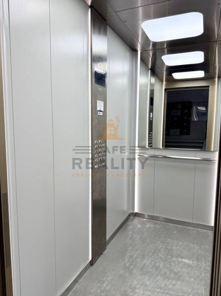 Lift belső tér rozsdamentes acél panellel és tükörrel egy egyszobás lakásban.