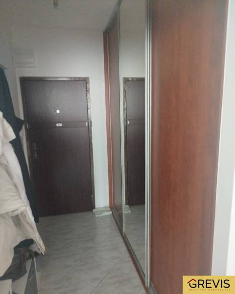 Folyosó csempével és nagy tükörrel a garzonlakásban.