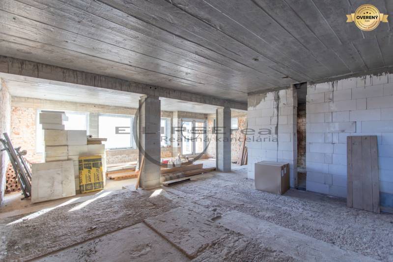 Egy építés alatt álló épület belseje építőanyaggal és betonmennyezettel.