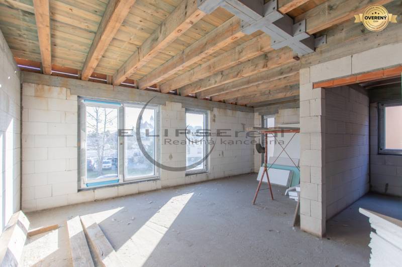 Egy építés alatt álló épület belső tere fa mennyezettel és nagy ablakokkal.