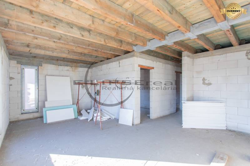 Építés alatt álló épület fa mennyezettel és építőanyagokkal a belső térben.