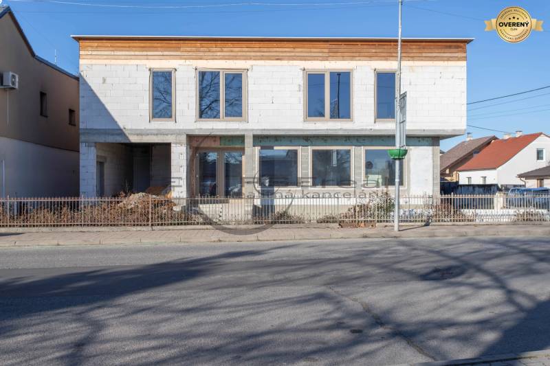 Egy befejezetlen homlokzatú épület Nagylévárdon, az út mellett áll.