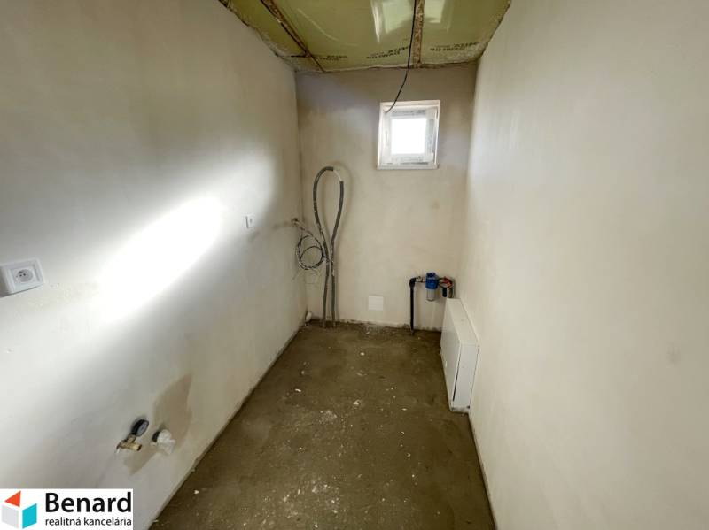 Üres szoba ablakkal egy családi házban, látható szerelvények és előkészítés a berendezéshez.